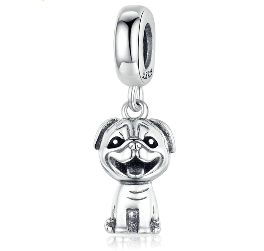 Silver dog-shaped charm on a white background