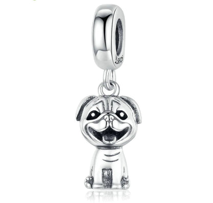 Silver dog-shaped charm on a white background